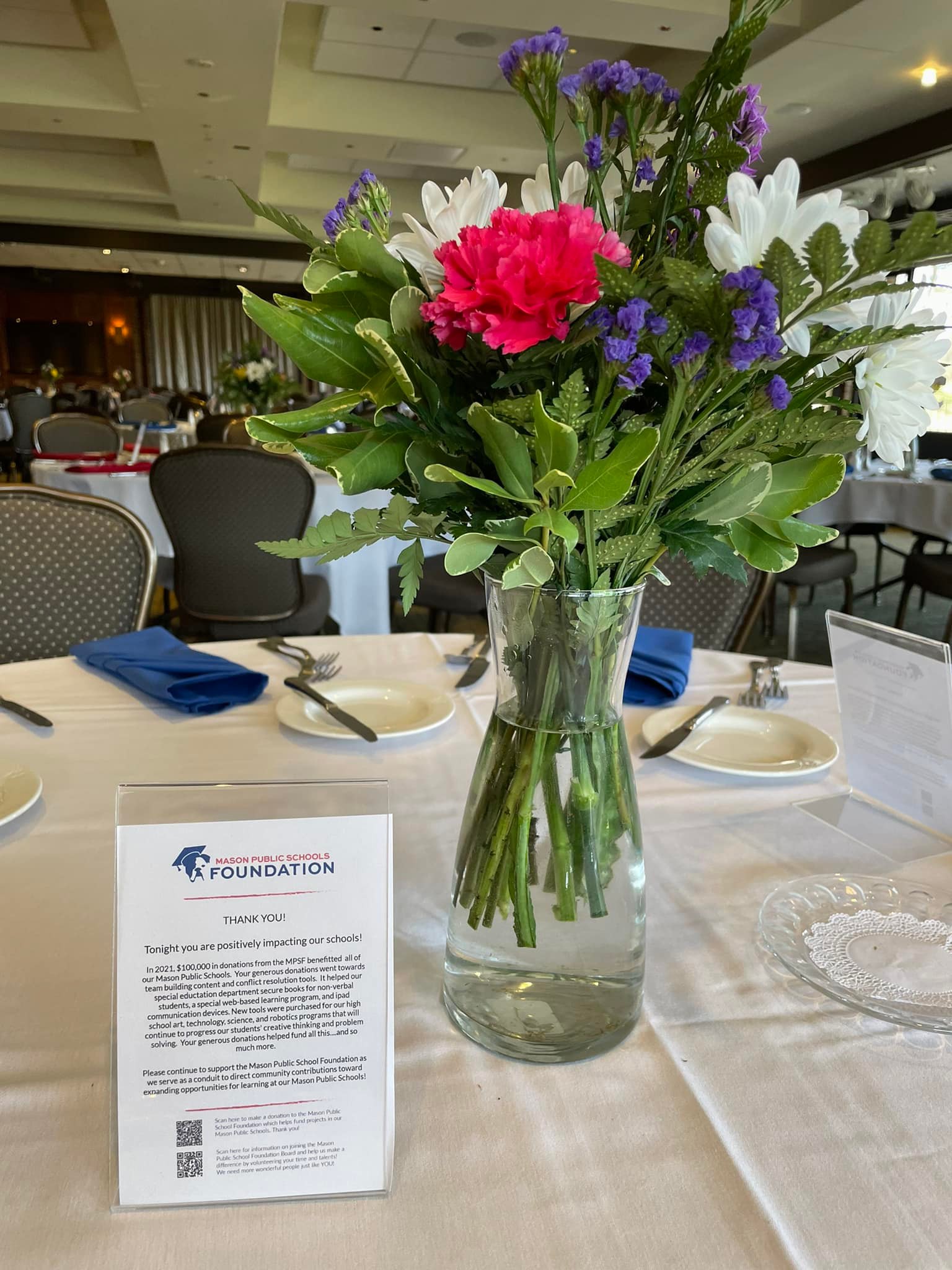 Flowers and a Mason Public Schools Foundation display at a community event